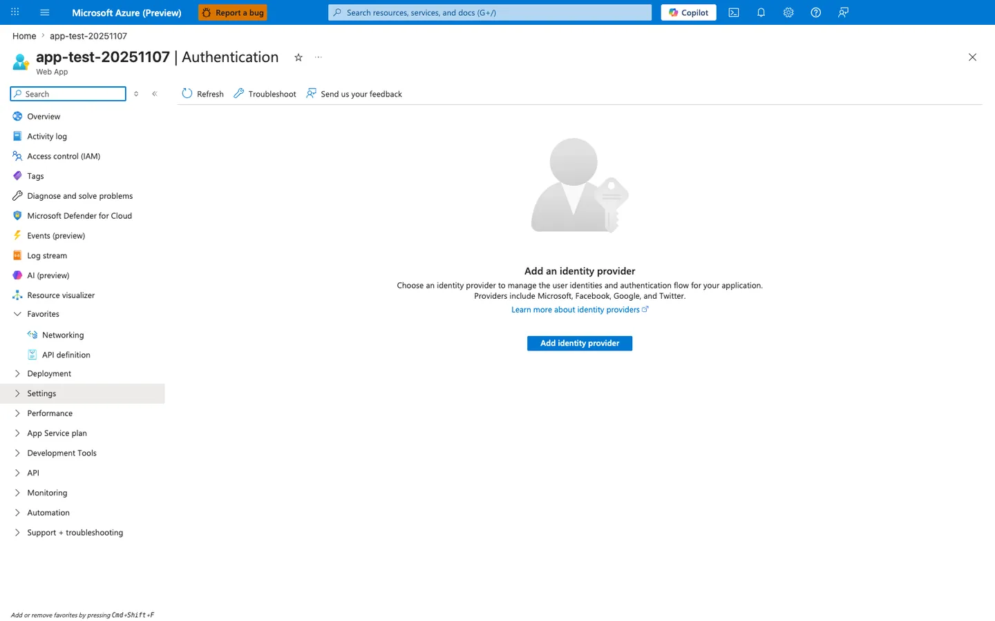 Authentication blade for the Web App with a minimal command bar offering Refresh, Troubleshoot, and Send us your feedback actions. The main content area is an empty state with a large silhouette-and-key avatar icon, a heading "Add an identity provider", a subtitle reading "Choose an identity provider to manage the user identities and authentication flow for your application. Providers include Microsoft, Facebook, Google, and Twitter.", a "Learn more about identity providers" link, and a primary blue "Add identity provider" call-to-action button. The left navigation has the Settings group highlighted.