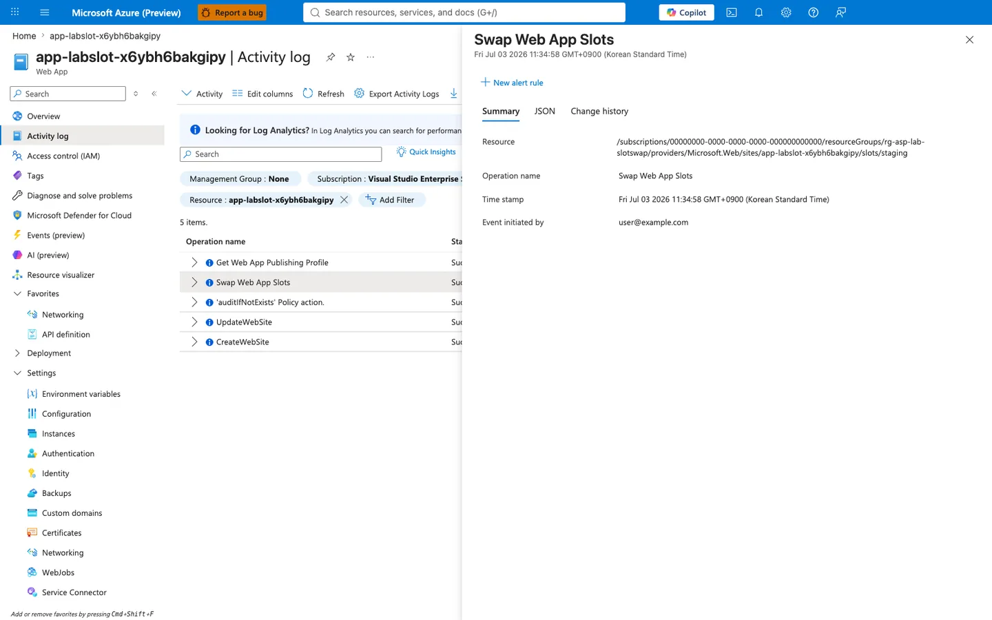 Azure portal Activity log blade for Web App app-labslot-x6ybh6bakgipy with breadcrumb "Home > app-labslot-x6ybh6bakgipy". Blade heading reads "app-labslot-x6ybh6bakgipy | Activity log" and the left navigation shows Activity log highlighted. The main grid shows 5 items filtered by Subscription "Visual Studio Enterprise Subscription" and Resource "app-labslot-x6ybh6bakgipy". Rows include Get Web App Publishing Profile, Swap Web App Slots (selected/highlighted), 'auditIfNotExists' Policy action, UpdateWebSite, and CreateWebSite. The right complementary detail panel is open on the Swap Web App Slots row with sub-heading "Fri Jul 03 2026 11:34:58 GMT+0900 (Korean Standard Time)" and tabs Summary, JSON, Change history — Summary tab is active. The selected row shows Status "Succeeded". Detail rows show a full ARM resource path ending in "/slots/staging", Operation name "Swap Web App Slots", Time stamp "Fri Jul 03 2026 11:34:58 GMT+0900 (Korean Standard Time)", and Event initiated by "user@example.com".