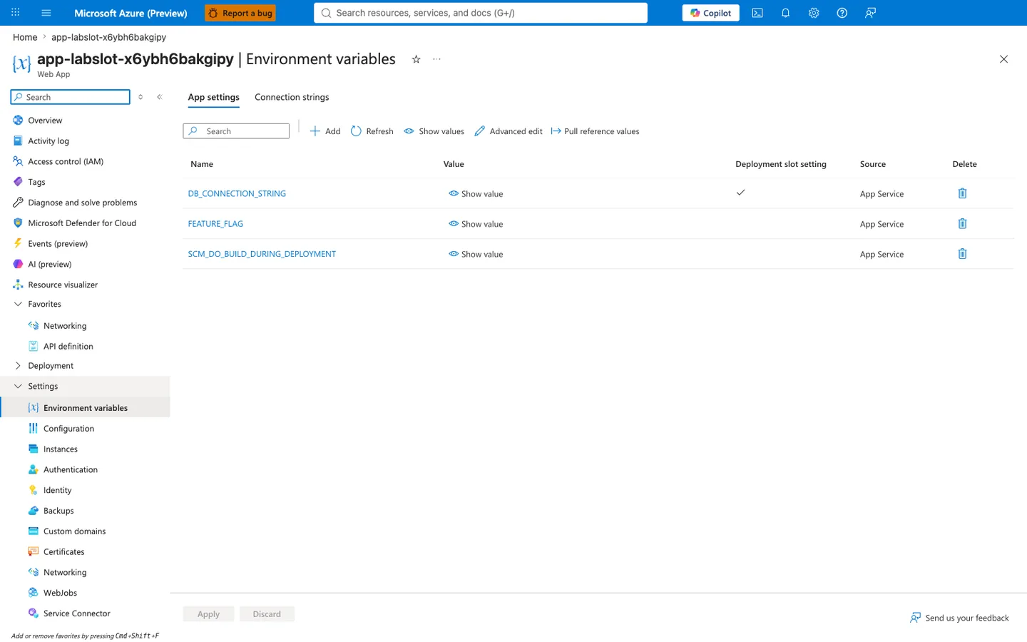 Azure portal Environment variables blade for Web App app-labslot-x6ybh6bakgipy with breadcrumb "Home > app-labslot-x6ybh6bakgipy". Blade heading reads "app-labslot-x6ybh6bakgipy | Environment variables" and the "App settings" tab is active (sibling tab: Connection strings). The grid has five columns in order: Name, Value, Deployment slot setting, Source, Delete. Three rows are shown, all with values hidden behind "Show value" links and Source "App Service". The DB_CONNECTION_STRING row has the Deployment slot setting checkbox CHECKED (sticky). The FEATURE_FLAG row has the Deployment slot setting checkbox UNCHECKED (non-sticky). The SCM_DO_BUILD_DURING_DEPLOYMENT row has the Deployment slot setting checkbox UNCHECKED (non-sticky). The left navigation shows Settings expanded with Environment variables highlighted. Apply and Discard buttons at the bottom are both disabled, confirming the displayed state matches the persisted configuration.