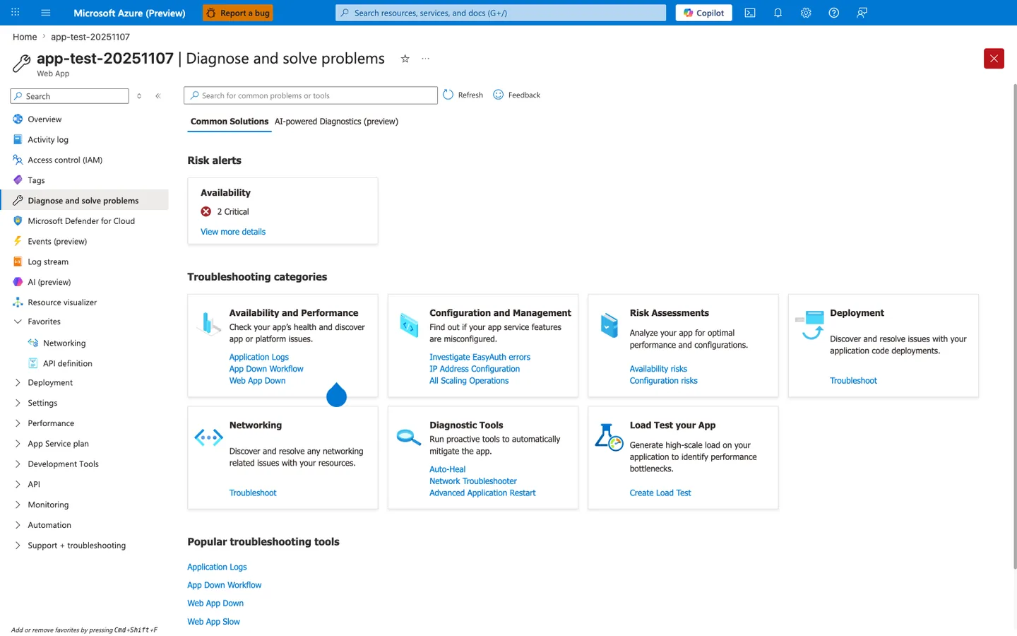 Azure portal Diagnose and solve problems blade for app-test-20251107 (Web App). The blade header shows the resource title with Favorite (star) and More content actions (...) buttons on the left, and a prominent red Close (X) button at the far right. Below the header, the toolbar shows a Search for common problems or tools box, a Refresh button, and a Feedback button. Two tabs are visible: Common Solutions (selected and underlined) and AI-powered Diagnostics (preview). The Risk alerts section at the top displays a single card titled Availability with a red X icon, the count 2 Critical, and a View more details link. Below that, the Troubleshooting categories section shows seven tiles arranged in two rows: Availability and Performance with sub-links Application Logs, App Down Workflow, Web App Down; Configuration and Management with sub-links Investigate EasyAuth errors, IP Address Configuration, All Scaling Operations; Risk Assessments with sub-links Availability risks, Configuration risks; Deployment with sub-link Troubleshoot; Networking with sub-link Troubleshoot; Diagnostic Tools with sub-links Auto-Heal, Network Troubleshooter, Advanced Application Restart; and Load Test your App with sub-link Create Load Test. The Popular troubleshooting tools section at the bottom lists Application Logs, App Down Workflow, Web App Down, and Web App Slow as quick-access links. The left navigation panel highlights Diagnose and solve problems as the active blade, with Overview, Activity log, Access control (IAM), Tags, Microsoft Defender for Cloud, Events (preview), Log stream, AI (preview), Resource visualizer, Favorites (expanded with Networking and API definition), Deployment, Settings, Performance, App Service plan, Development Tools, API, Monitoring, Automation, and Support + troubleshooting also visible.