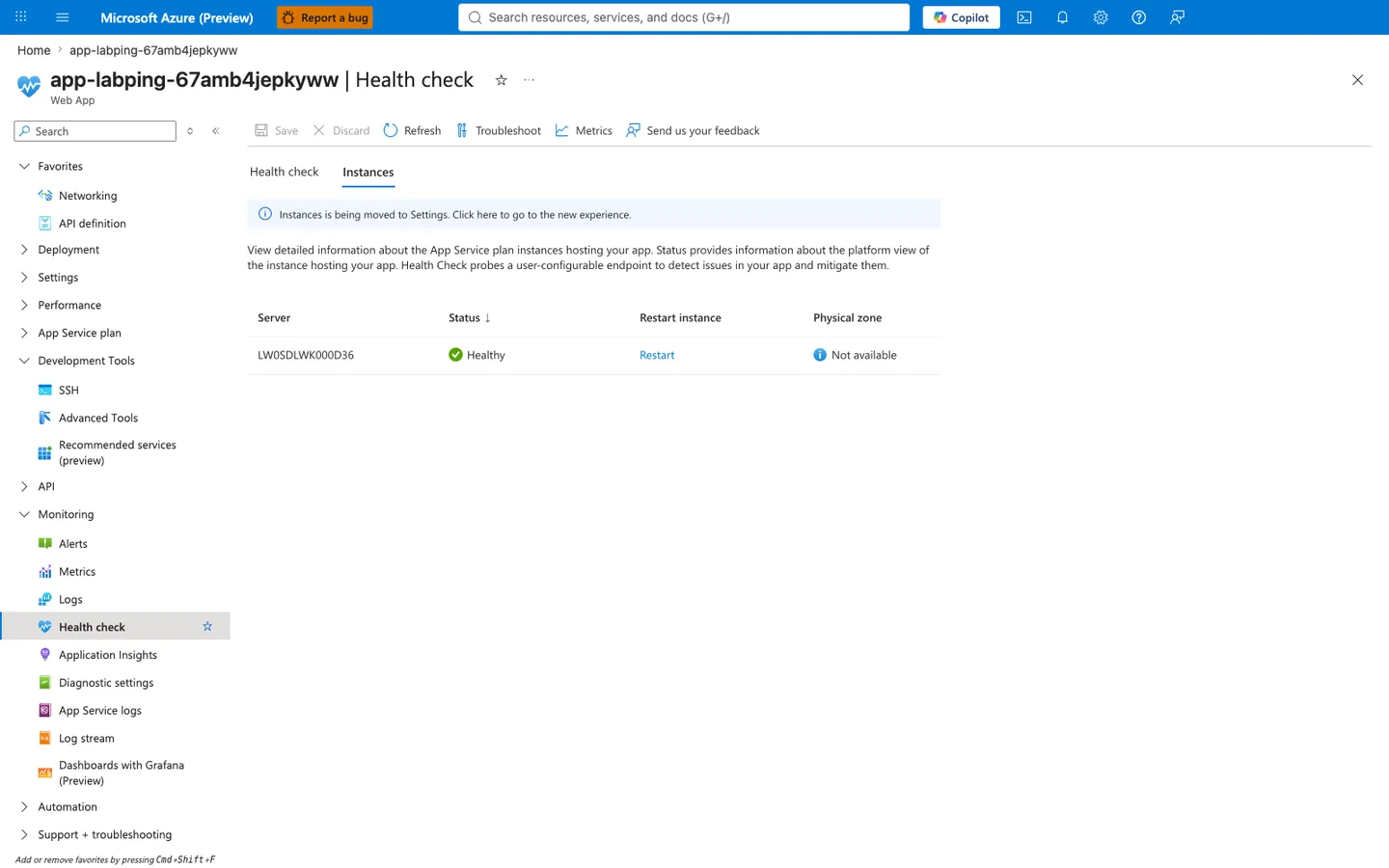 Azure Portal Health check blade for the deployed Linux Web App showing the standard command bar (Save, Discard, Refresh, Troubleshoot, Metrics, Send us your feedback), two tabs "Health check" and "Instances" with Instances selected, a single informational banner reading "Instances is being moved to Settings. Click here to go to the new experience.", a descriptive paragraph explaining "View detailed information about the App Service plan instances hosting your app. Status provides information about the platform view of the instance hosting your app. Health Check probes a user-configurable endpoint to detect issues in your app and mitigate them.", and a table with columns Server, Status (sorted descending), Restart instance, and Physical zone containing a single row: server LW0SDLWK000D36, Status "Healthy" rendered in green with a check icon, a Restart action link, and "Not available" in the Physical zone column. The left navigation shows the Monitoring group expanded with Health check highlighted.